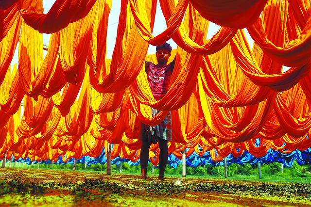 2023年服装纺织品出口额占据了孟加拉国总出口贸易的83%。图为孟加拉国工人在晾晒纺布。（法新社）